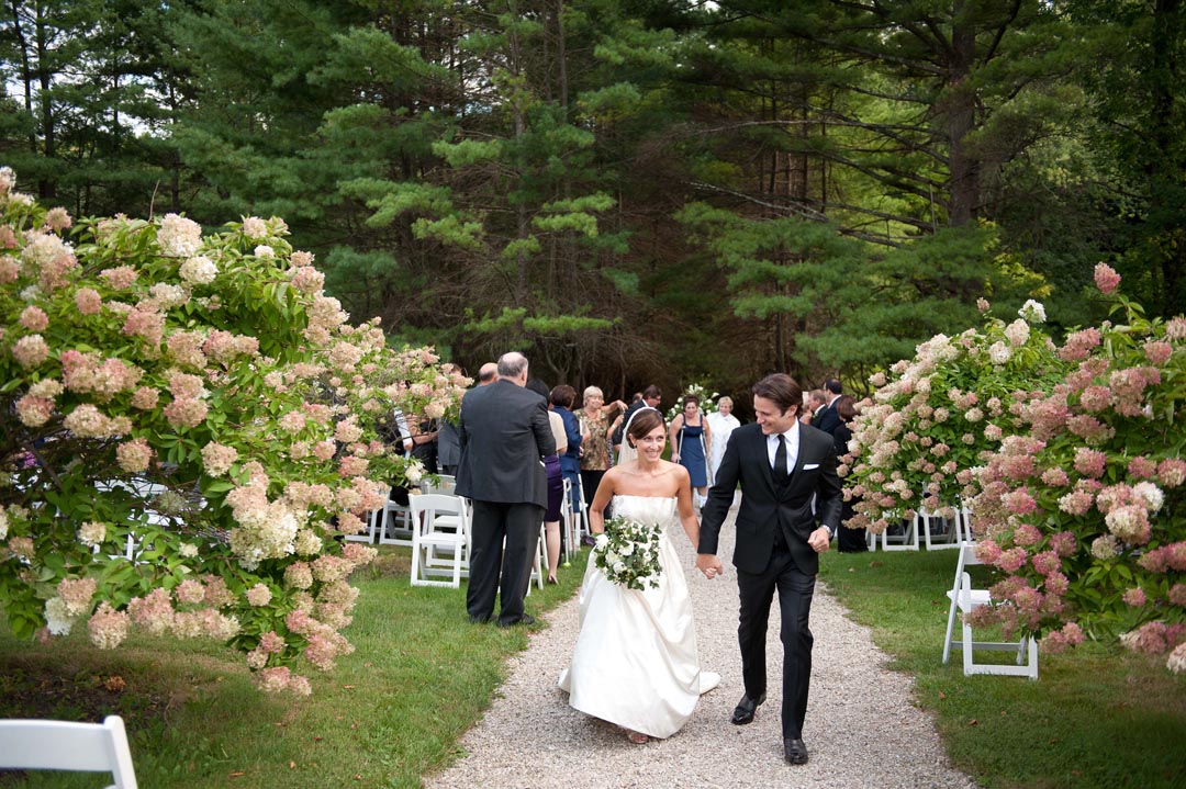 A bride and Groom walking up the path after saying I do at Seven Hills Inn